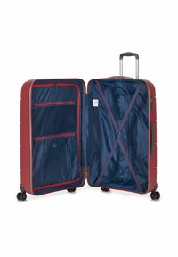 Maleta dura roja, abierta para revelar un interior azul marino con compartimentos con cremallera y correas cruzadas para asegurar el contenido.