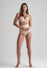 Set di lingerie a due pezzi nudo con reggiseno imbottito e sagomato e slip a vita alta, entrambi realizzati in un tessuto liscio e opaco.