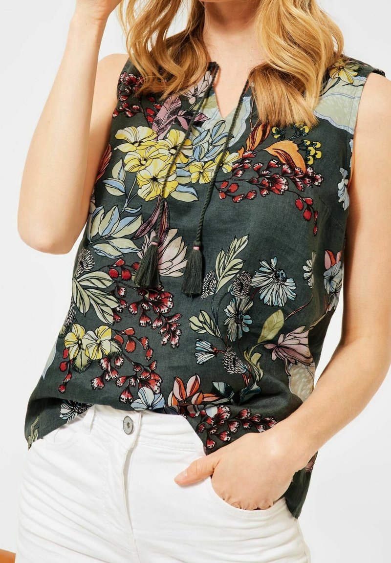 Floral sleeveless blouse in dark green fabric, featuring yellow and pink flowers, intricate patterns, and a keyhole neckline with tassels.