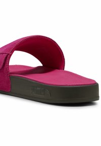 Fuksijinės šlepetės su storesniu, tekstūruotu padu. Papildyta plačia juostele ir iškilniu logotipu šone. Minkšta medžiaga ir atviras dizainas.