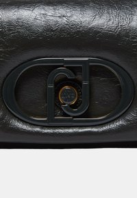 Bolso de mano de piel sintética negra con un diseño rectangular, textura brillante y un cierre de hardware geométrico prominente.