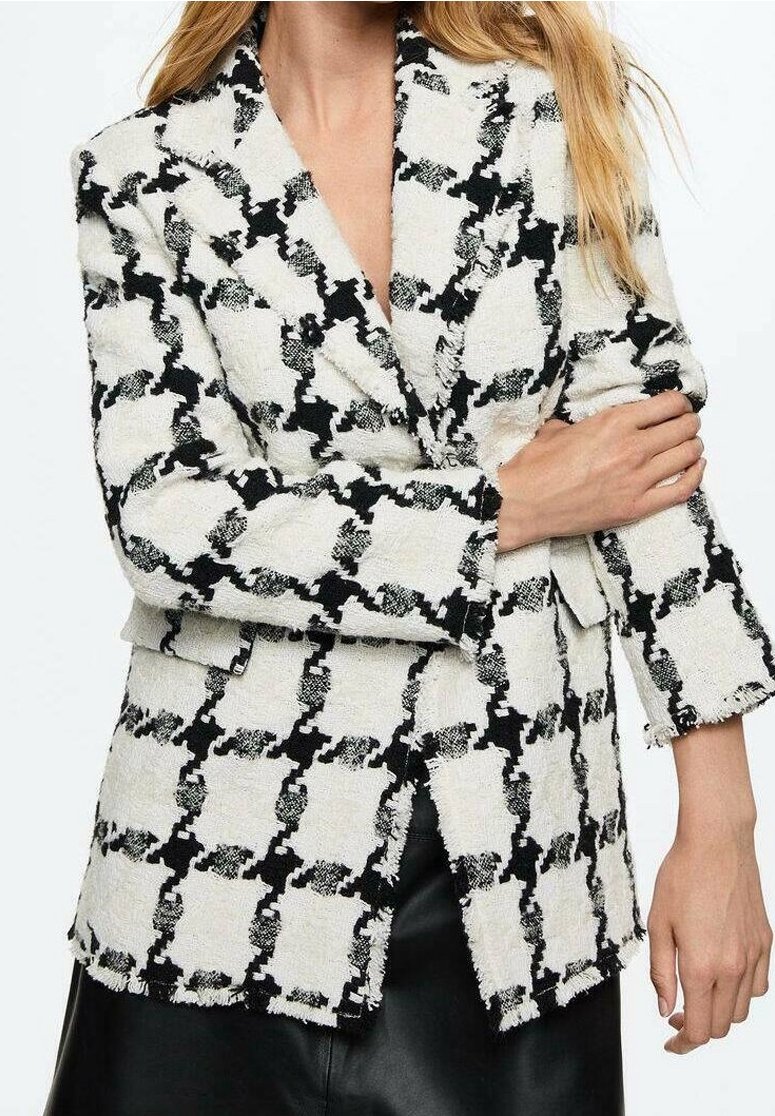 Blazer a rayas en blanco y negro, hecho de una tela texturizada, con cuello de muesca y bordes ligeramente deshilachados.