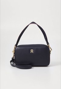 Borsa in pelle blu navy con forma rettangolare, accessori in oro e una zip rossa a contrasto. Dotata di tracolla rimovibile e manico superiore.