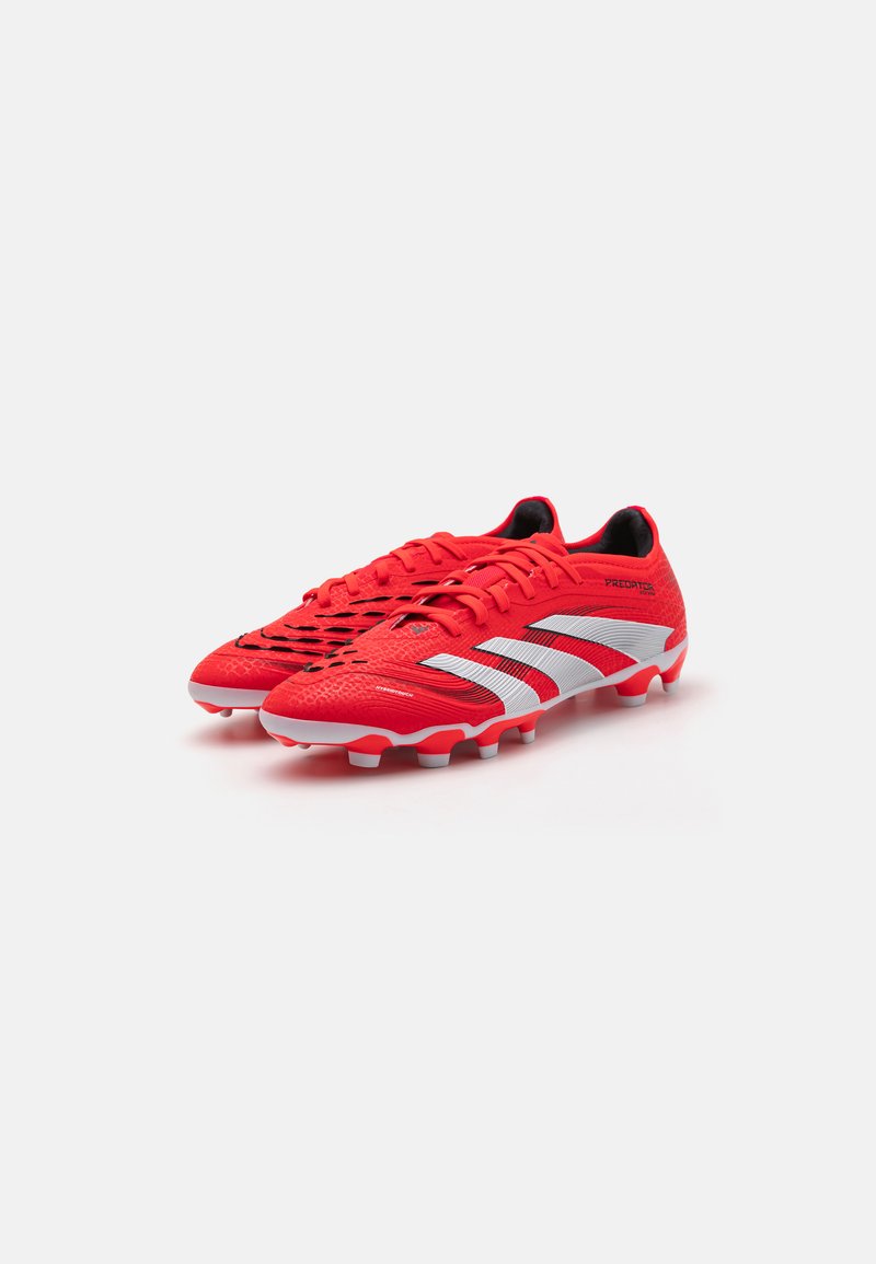 Rote Fußballschuhe mit einer strukturierten synthetischen Oberseite, die weiße Akzente und ein Schnürdesign aufweisen. Gummisohle mit Stollen für Traktion.