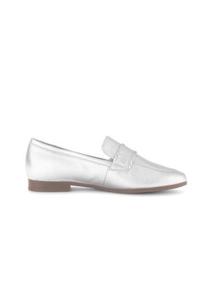 Mocassin plat en cuir blanc avec petit talon marron et détail de bride cousue sur le dessus, vu de côté.