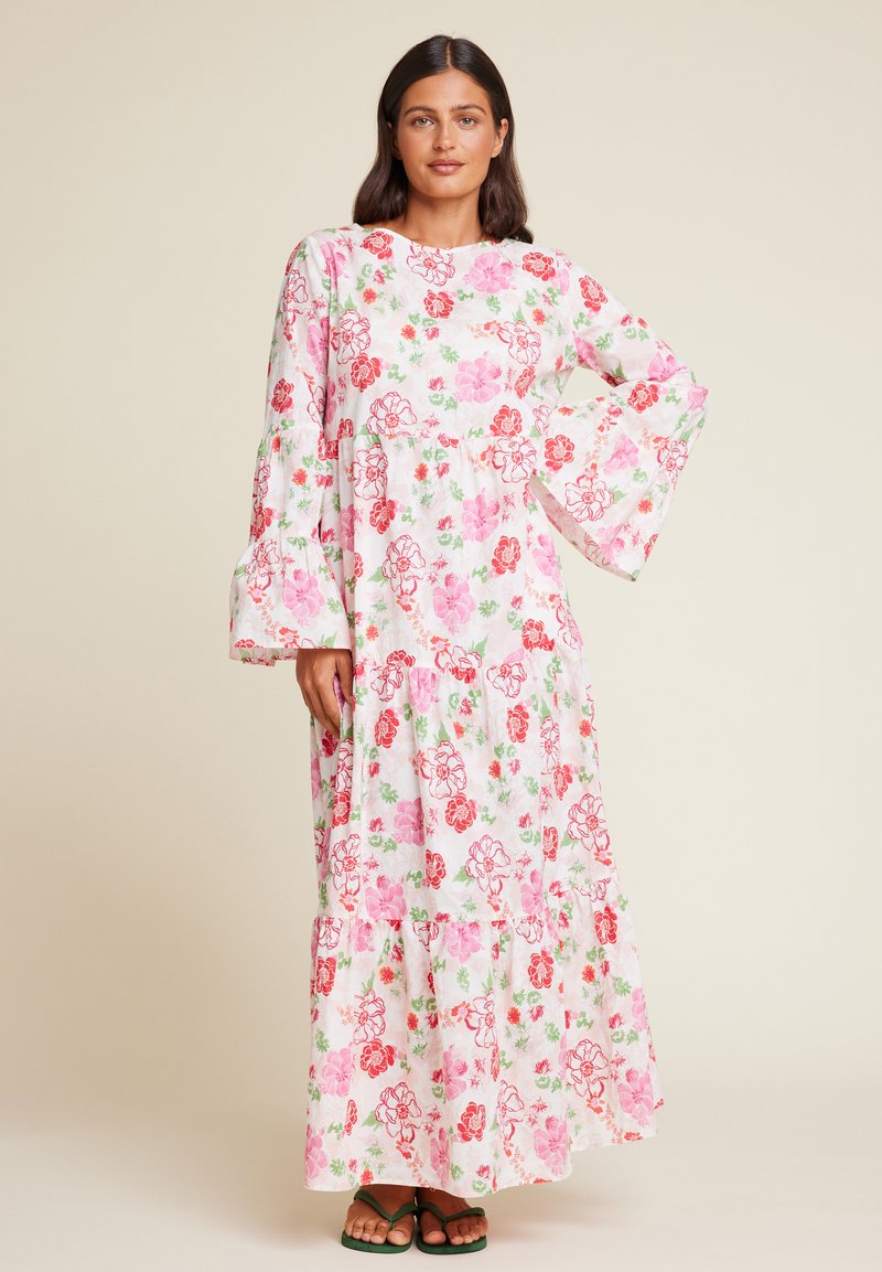 Maxikjole i lett, hvitt stoff med blomsterdesign i rosa og rødt. Den har lange klokkeermer og lagdelte detaljer nederst.