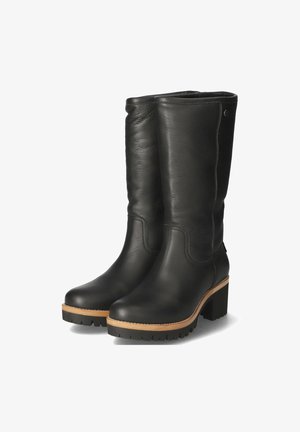 Schwarze Leder-Stiefel bis zum Knie mit strukturierter Oberfläche, in tapered Form und mit einem klobigen Holzabsatz. Die Sohle hat ein robustes Profil.