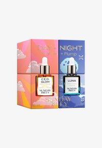 Ensemble de deux huiles pour le visage dans des boîtes colorées, l'une dorée et orange, l'autre bleue. Comprend un flacon compte-gouttes avec un couvercle noir et un bulbe blanc.