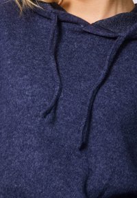 Marineblauwe fleece hoodie met een zachte textuur, een voorkantzak en een trekkoord bij de hals. De stof heeft een warme, gezellige uitstraling.