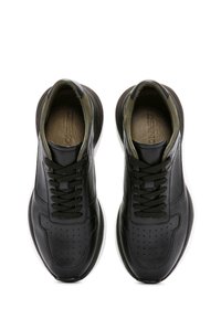 Sneakers in pelle nera con punta rotonda, dettagli perforati e lacci tono su tono. Presentano un design elegante e una suola in gomma bianca a contrasto.