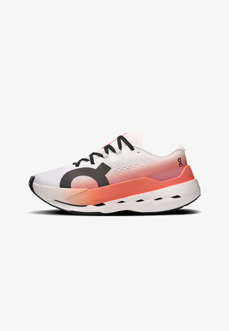Chaussure de sport blanche et corail avec lacets noirs, logo noir sur le côté, dessus respirant et semelle épaisse et amortie avec des découpes géométriques.