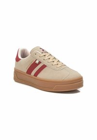 Sneaker in suede beige con strisce rosse e suola in gomma. Caratteristiche includono lacci rotondi e marchio sulla linguetta e sul lato.