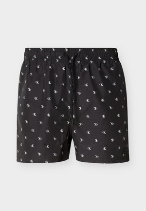 Zwarte zwemshorts met een wit herhaald "cK"-logo patroon, een elastische tailleband en een zwarte koordsluiting aan de voorkant.