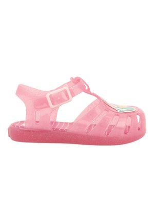 Sandaal de plástico rosa con acabado brillante, diseño de punta abierta, correa ajustable con hebilla y detalle de acento floral en la punta.