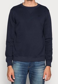 Marineblaue Sweatshirt aus Baumwollmischgewebe, mit Rundhalsausschnitt, langen Ärmeln und gerippten Bündchen mit dezenten Steppnähten.
