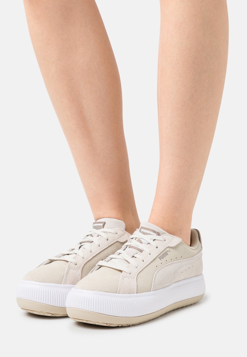 Baskets en suède beige avec une semelle blanche épaisse, design à lacets et logo PUMA sur la languette et le côté. Accents texturés sur la semelle.