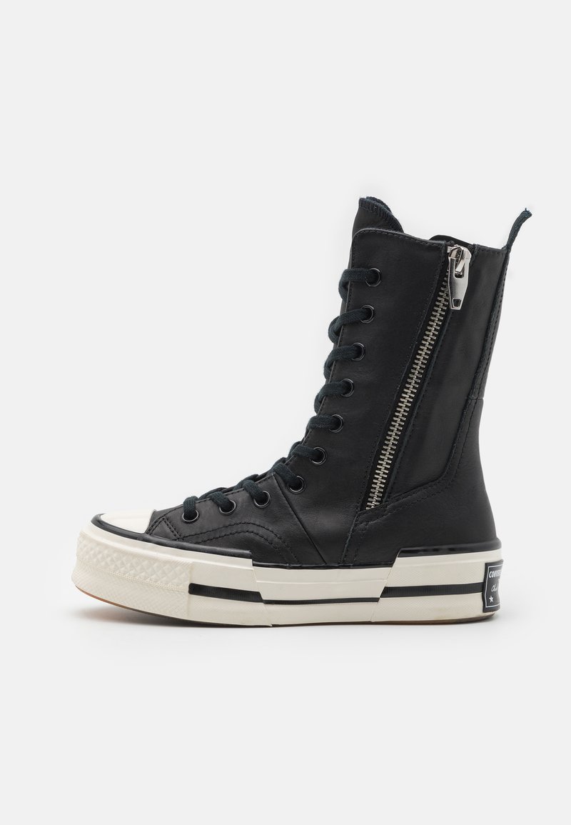 Høytopp svart lær sneakers med glidelås, rund tå, kontrasterende hvit såle og svarte snøringer, med teksturert design og logo.