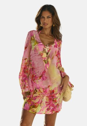 Durchsichtiger rosa Überwurf mit floralen Mustern, V-Ausschnitt und langen Ärmeln, mit einem goldfarbenen Akzent am Ausschnitt. Strukturierter Stoff.