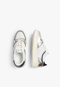 Zapatillas de deporte bajas en blanco y plateado metálico con acentos en azul marino, cordones blancos y suelas de goma texturizadas, mostradas desde vistas superior y lateral.
