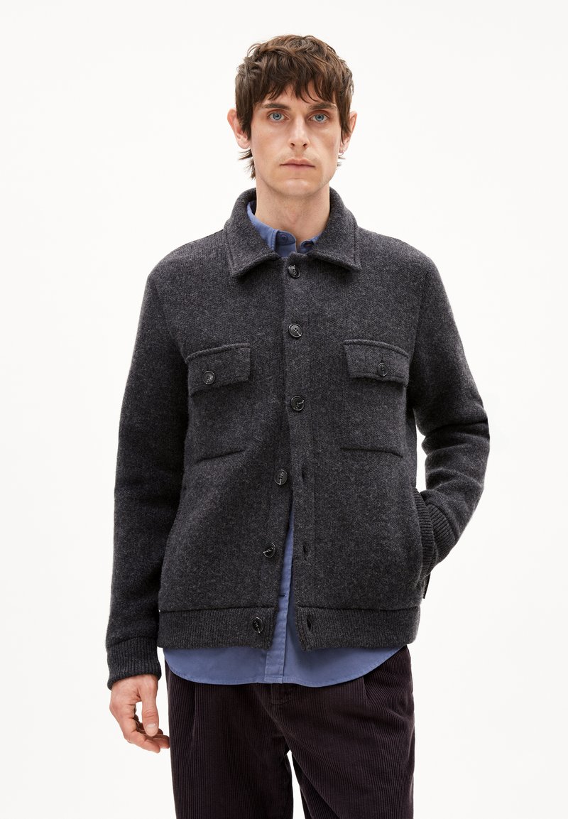 Wollmischungsjacke in Dunkelgrau mit klassischem Kragen, zwei Brusttaschen, Knopfverschlüssen sowie gerippten Bündchen und Saum. Glatte Oberfläche.