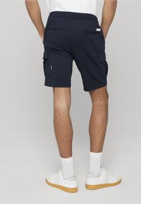 Shorts cargo bleu marine en tissu à texture lisse ; dotés de deux poches latérales, deux poches arrière et d'une taille élastique.