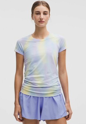 Leichtes, pastellfarbenes Batik-T-Shirt mit kurzen Ärmeln und gerafftem Saum, kombiniert mit lockeren lavendelfarbenen Shorts. Glatte Stoffstruktur.