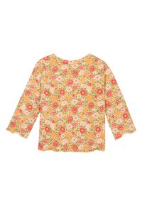 Bloes met bloemenprint in pastelroze achtergrond met rode, oranje en groene bloemenpatronen, ronde halslijn en driekwartmouwen.