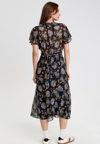 Sort blomstret midi-kjole med korte, svajende ærmer, prydet med blå og pink blomster. Designet med en indsnittet talje og bånd, lavet af letvægtsmateriale.