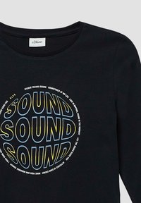 Zwarte lange mouw t-shirt met een cirkelvormige 'SOUND' grafiek in vetgedrukt geel en blauwe tekst, met extra tekst in een kleiner lettertype.