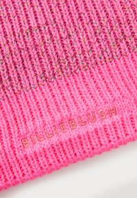 Rožinis mezginys kepurė su tekstūruotu raštu ir glotnia apdaila. Išskirtinai su metaline siūle ir auksu siuvinėtu "BILLIEBLUSH" ženklu.