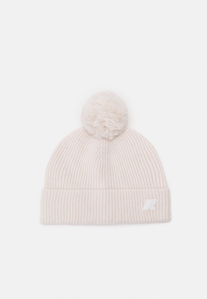 Light pink knit beanie with a plush pom-pom on top, ribbed texture, and a white logo patch on the folded cuff.