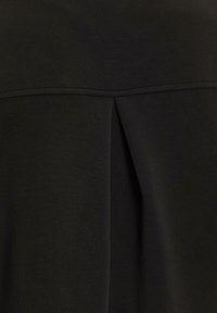 Schwarzes Top aus strukturiertem Stoff mit leichtem Glanz, das eine Falten-Details auf der Rückseite und ein glattes, einfaches Design zeigt.
