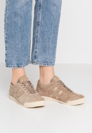 Baskets en suede beige avec un design texturé, dotées de rayures beige clair, de lacets plats et d'une semelle en caoutchouc blanc.