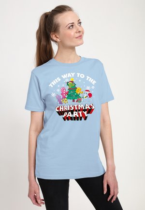 Lyseblå bomulds T-shirt med et farverigt grafisk motiv, der viser forskellige tegneseriefigurer omkring et juletræ, teksten lyder "DENNE VEJ TIL JULEFESTEN."