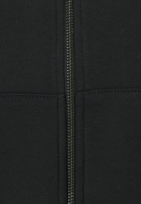 Black zip-up hoodie with a smooth exterior, featuring a central zipper, and front pockets. The fabric appears soft and textured.