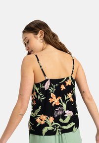 Top negro con estampado floral que presenta patrones botánicos en naranja y verde, con tirantes delgados ajustables y un corte relajado. Tejido texturizado.