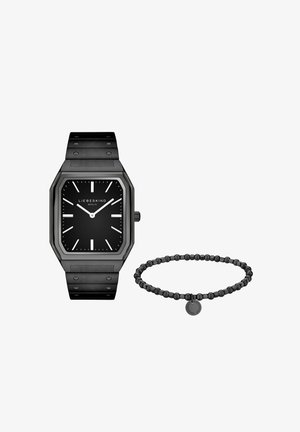 Sort rektangulært armbåndsur med sort urskive og hvide markører ved siden af et matchende sort perlearmbånd med rund mærkat.