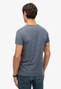 T-shirt da uomo a girocollo in tessuto blu melangiato. Maniche corte, forma aderente, con una texture liscia e dettagli di cucitura minimi.