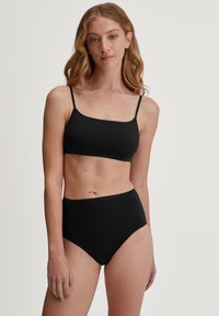 Zwarte bikinitop met dunne bandjes en een rechthoekige halslijn, gecombineerd met hoge taille zwarte bikini slipjes, beide in een gladde, rekbare stof.