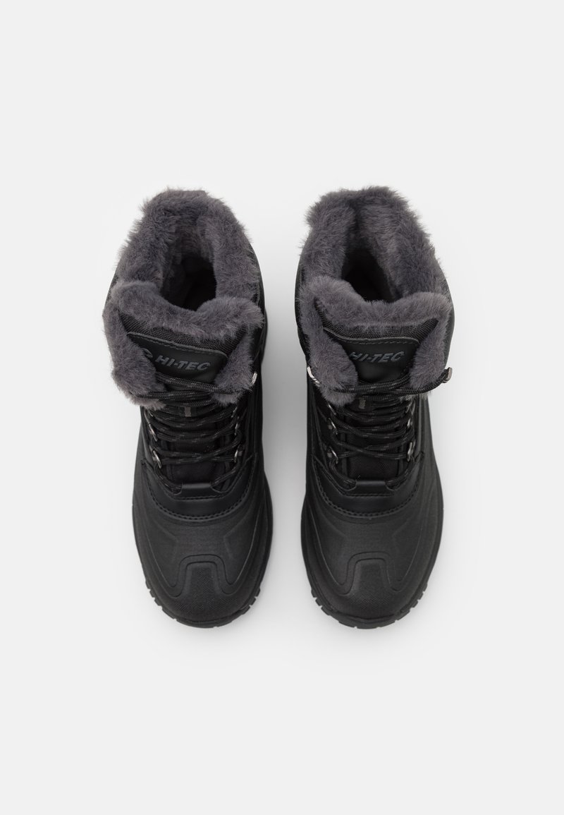 Botas negras aislantes con forro de piel sintética y una suela de goma resistente. Presentan un diseño con cordones y un collar acolchado para mayor comodidad.