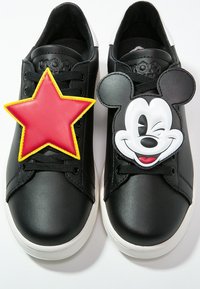 Svarta lädersneakers med en röd stjärna och en Mickey Mouse-grafik på framsidan, med svarta snören och vita gummisulor.