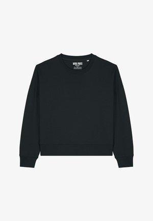 Czarna bluza z okrągłym dekoltem, opuszczonymi ramionami i ściągaczami przy rękawach. Połączona z niebieskimi dżinsami o luźnym kroju.