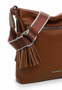 Brown leather crossbody bag with a textured finish, silver-accented strap, and decorative leather tassels on the side. Zipper closure.