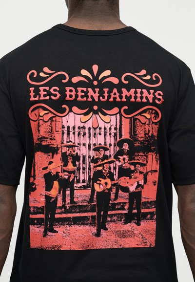 Dos d'une chemise noire avec un graphique rouge représentant six musiciens de mariachi portant des sombreros, jouant des instruments sur des marches en pierre, texte "LES BENJAMINS".