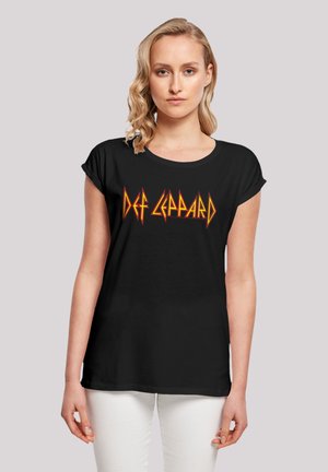 Schwarzes T-Shirt aus weichem Material, mit einem auffälligen roten und gelben "Def Leppard"-Logo in stilisierter Schrift über der Brust. Kurze Ärmel.