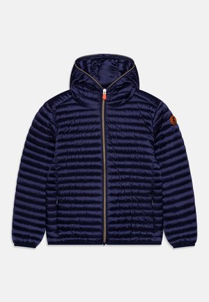 Veste matelassée légère bleu marine avec capuche, fermeture éclair intégrale à l'avant, poignets élastiques, poches latérales et écusson du logo sur la manche gauche.