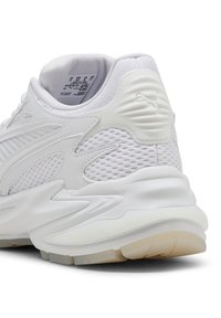 Vit Puma-sneaker med häl som har nät och syntetiska överdrag, vadderad krage och texturerad gummisula på en vit bakgrund.