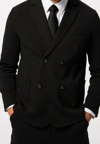 Blazer nero doppiopetto realizzato in tessuto morbido, dotato di due tasche frontali e bottoni neri, con rever a punta e una vestibilità slim.