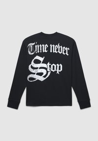 Czarna koszulka z długim rękawem z białym napisem "Czas nigdy się nie zatrzymuje" w zużytej czcionce, z luźnym krojem i okrągłym dekoltem.