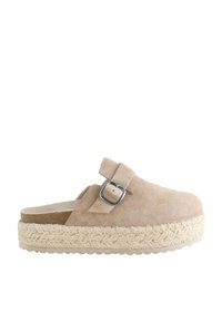 Zoccoli in camoscio beige con cinturino regolabile, suola in juta intrecciata stile espadrillas e plantare sagomato in sughero. Punta arrotondata.